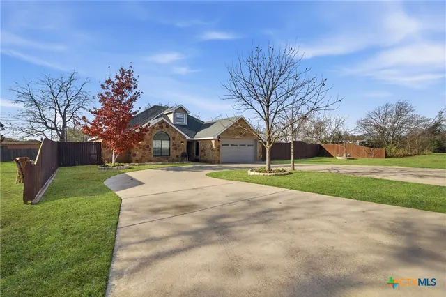 a view of a house with a big yard and large trees