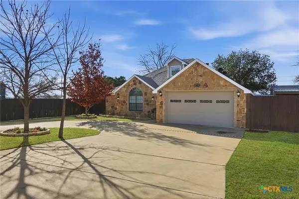 a view of a house with a yard and potted plants