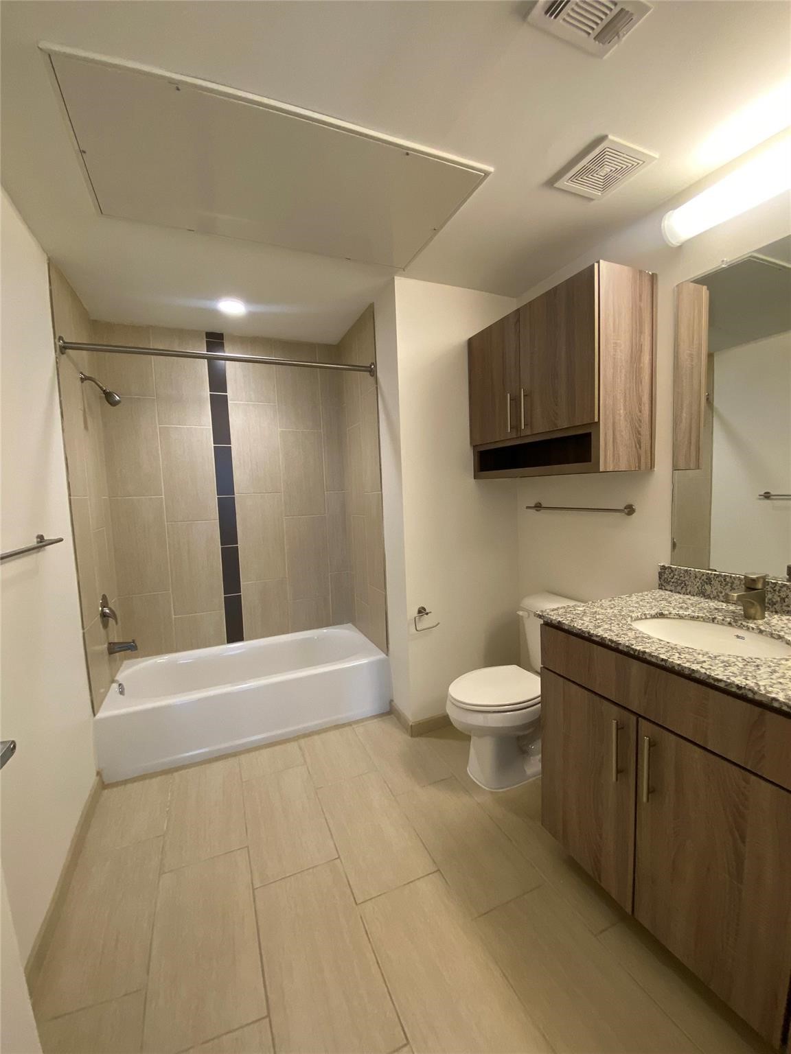 3550 Main Street, Unit 4416 Houston, TX 77002 - Photo 7 of 45 a bathroom with a granite countertop sink a toilet and a mirror