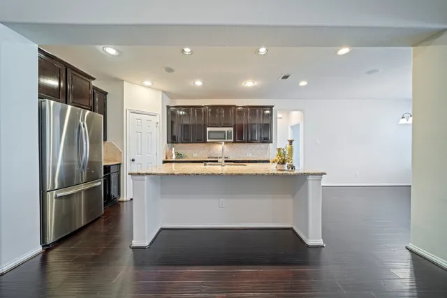 a kitchen with stainless steel appliances granite countertop a refrigerator and a sink