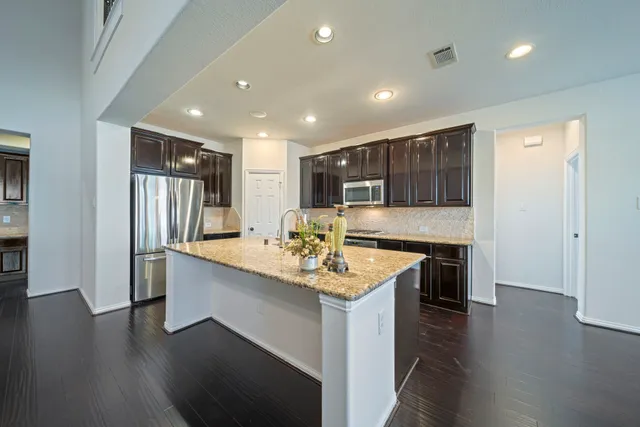 a kitchen with stainless steel appliances granite countertop a sink stove and refrigerator