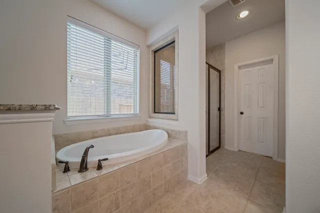 a bathroom with a tub a sink and a window
