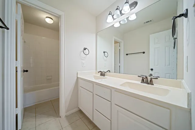 a bathroom with a sink tub and a mirror