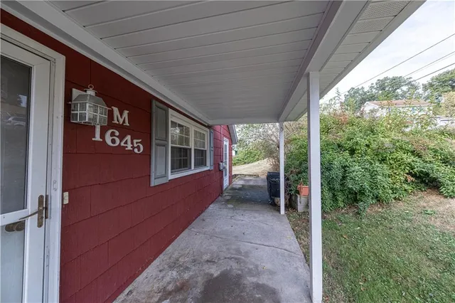 a view of a porch with furniture and floor to ceiling window