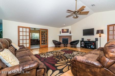 1930 Forbes Road St. Augustine, FL 32092 - Photo 11 of 24 a living room with furniture a fireplace and a flat screen tv