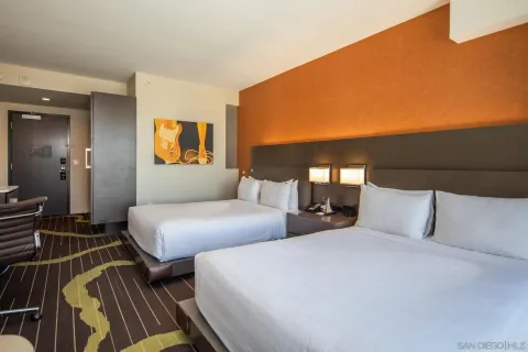 a bedroom with two beds and painting on the wall