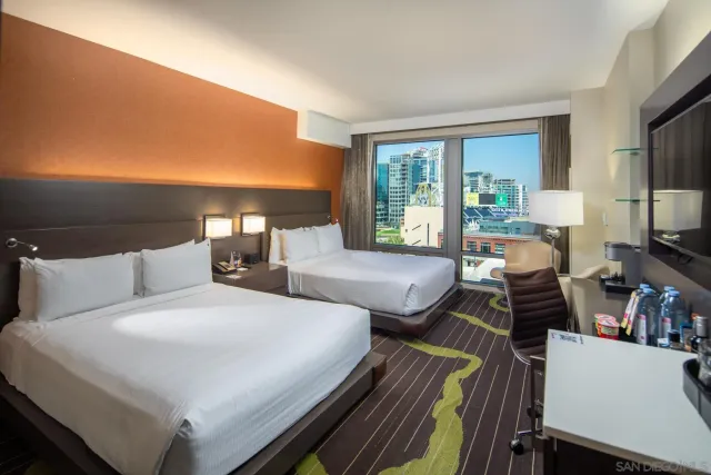 a bedroom with a bed a large window and flat screen tv