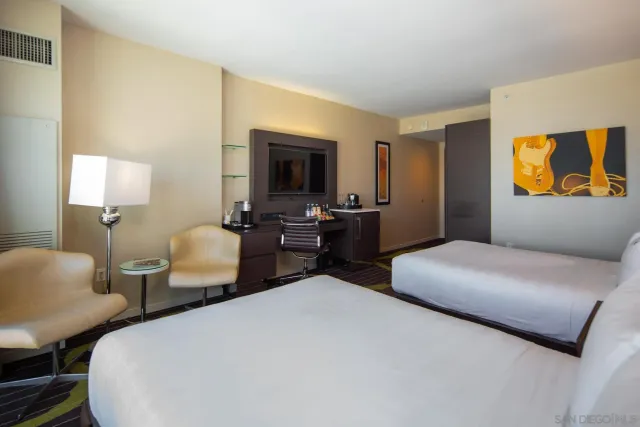 a bedroom with two beds and painting on the wall