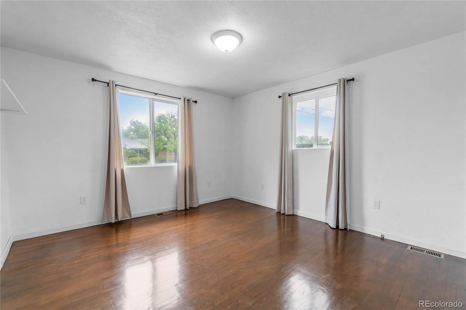 7010 West 44th Avenue Wheat Ridge, CO 80033 - Photo 21 of 31 an empty room with wooden floor and windows