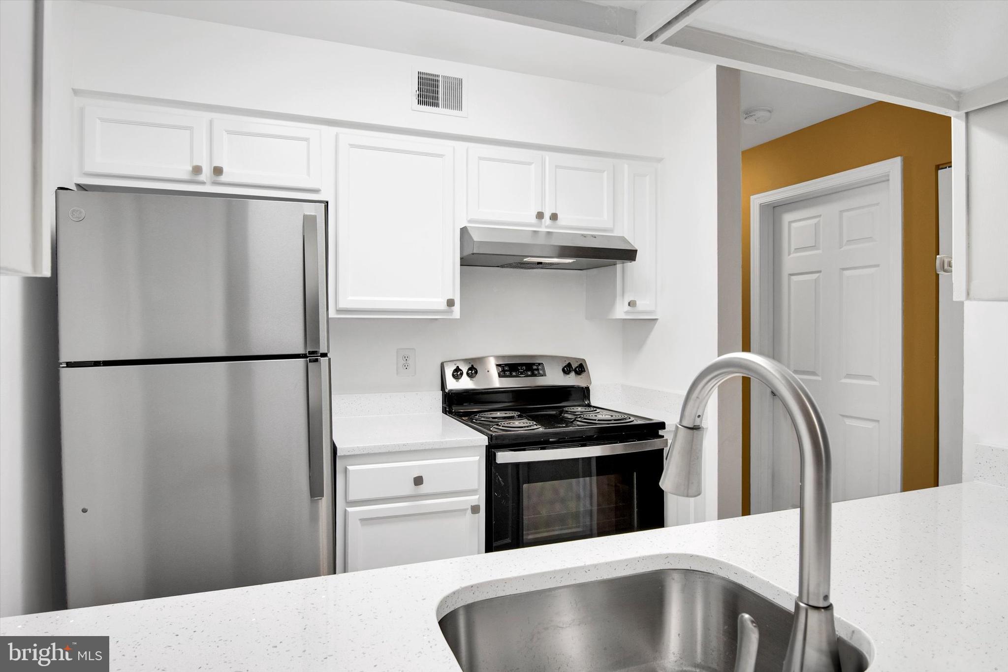 10310 Rein Commons Court, Unit 1B Burke, VA 22015 - Photo 5 of 23 a kitchen with stainless steel appliances granite countertop a refrigerator sink and stove