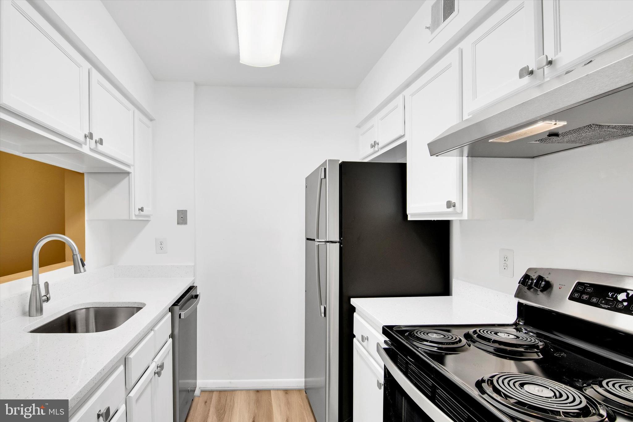 10310 Rein Commons Court, Unit 1B Burke, VA 22015 - Photo 6 of 23 a kitchen with a stove and a sink