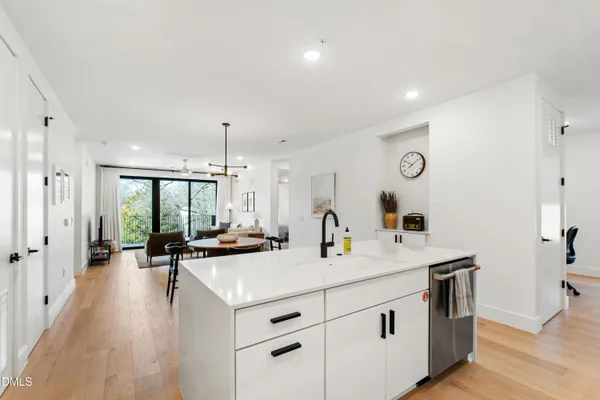 a view of a kitchen counter space with stainless steel appliances granite countertop a stove and a large window