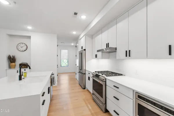 a kitchen with kitchen island stainless steel appliances a sink a stove cabinets counter top space