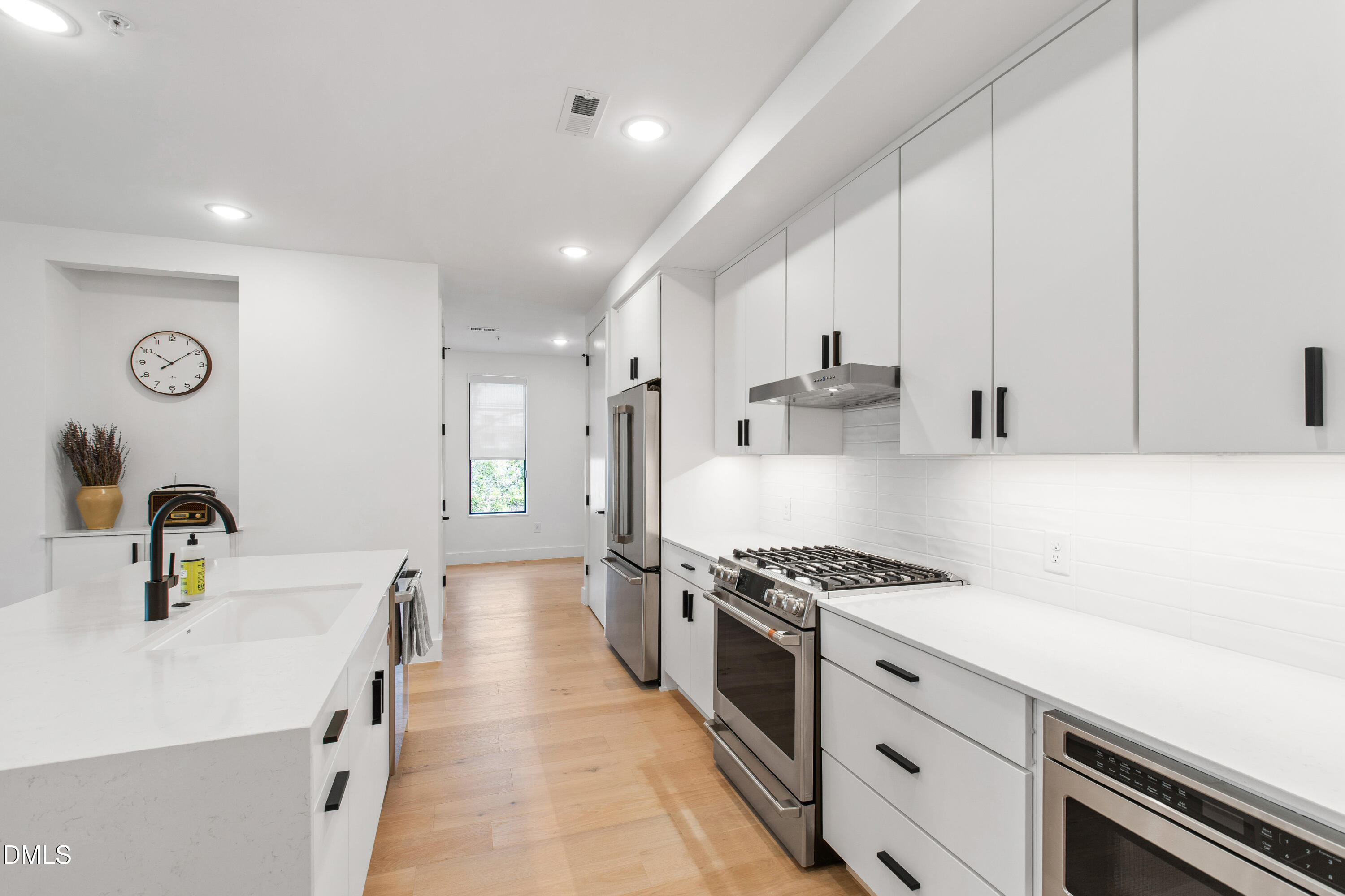 29 Enterprise Street, Unit 211 Raleigh, NC 27607 - Photo 12 of 48 a kitchen with kitchen island stainless steel appliances a sink a stove cabinets counter top space