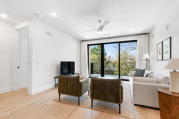 a living room with furniture large windows and a flat screen tv