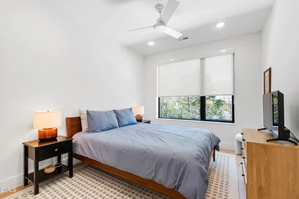 a bedroom with a bed tv and window