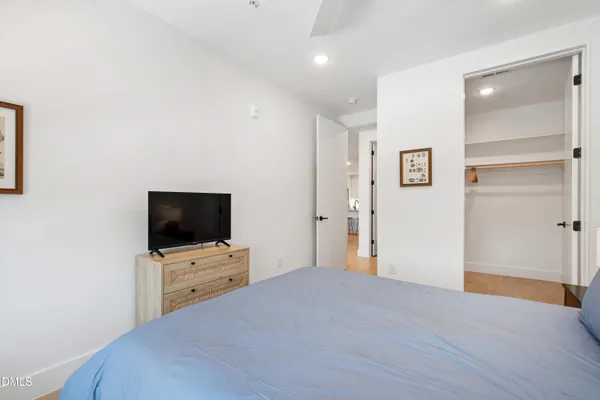 a bedroom with a bed and a flat screen tv