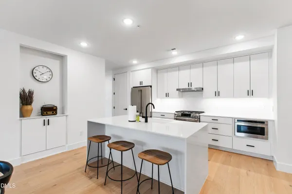 a kitchen with a sink a stove a refrigerator a dining table and chairs