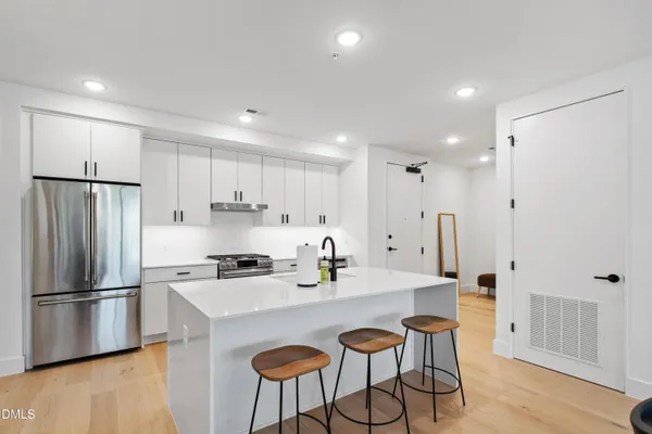 a kitchen with stainless steel appliances a refrigerator and a stove top oven