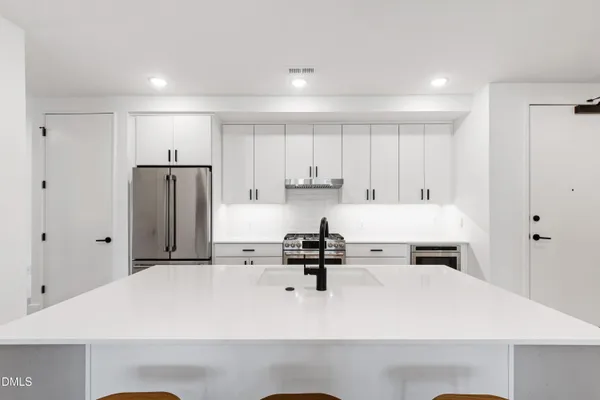 a kitchen with stainless steel appliances a refrigerator sink and cabinets