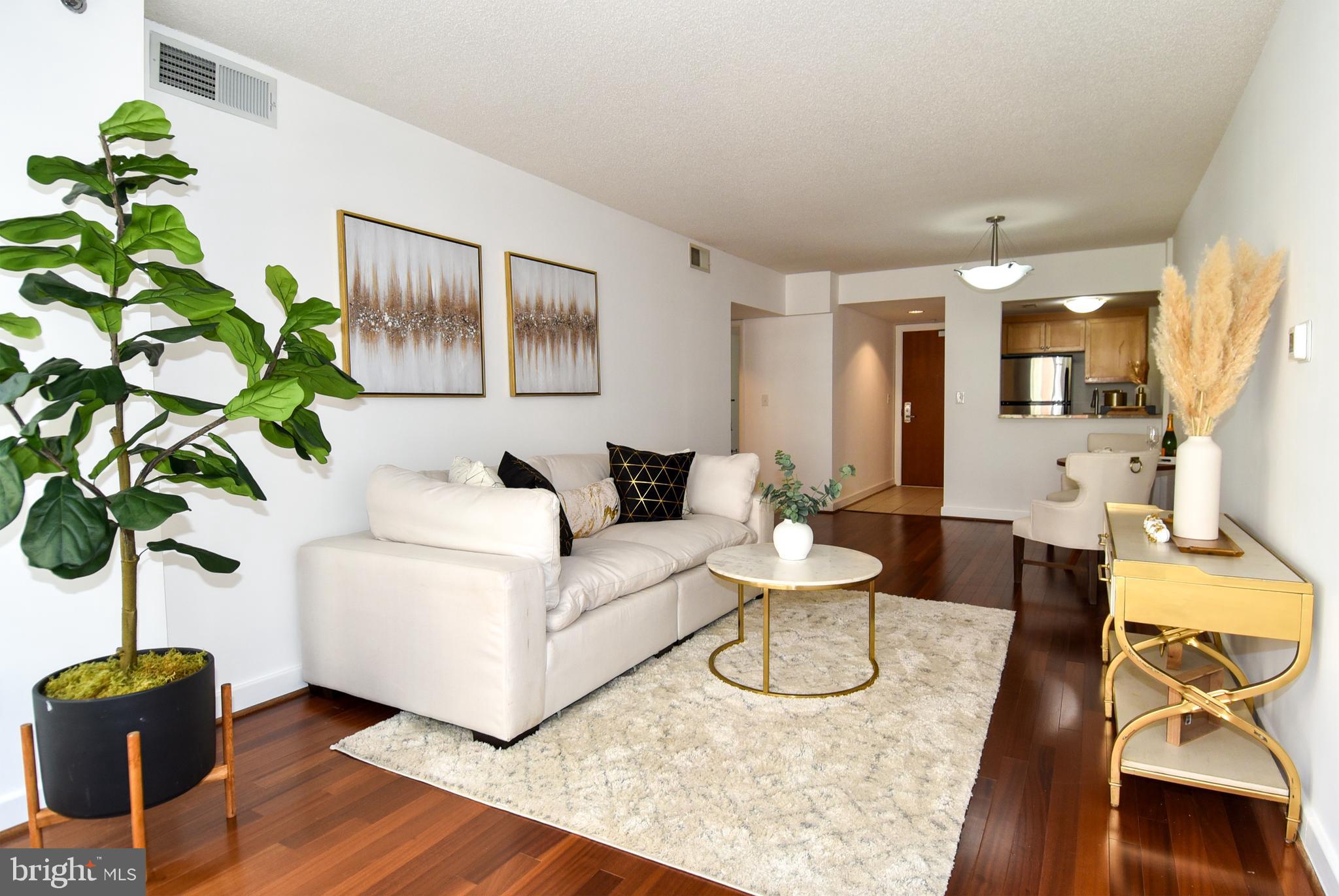 1150 K Street Northwest, Unit 408 Washington, DC 20005 - Photo 11 of 32 a living room with furniture a chandelier and a potted plant
