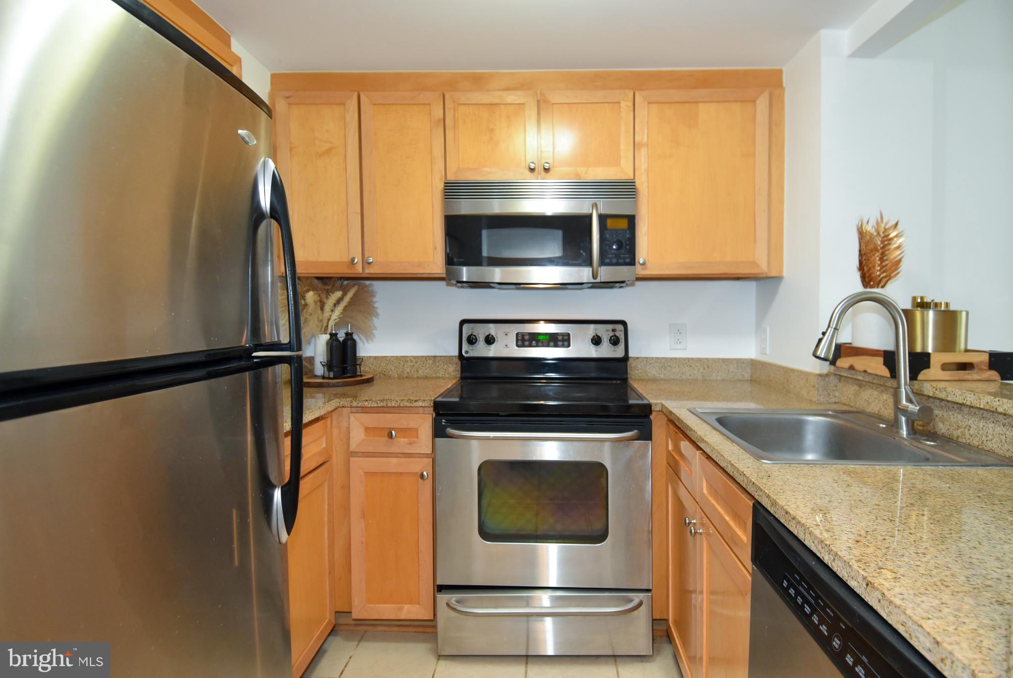 1150 K Street Northwest, Unit 408 Washington, DC 20005 - Photo 13 of 32 a kitchen with stainless steel appliances granite countertop a sink a stove and a refrigerator