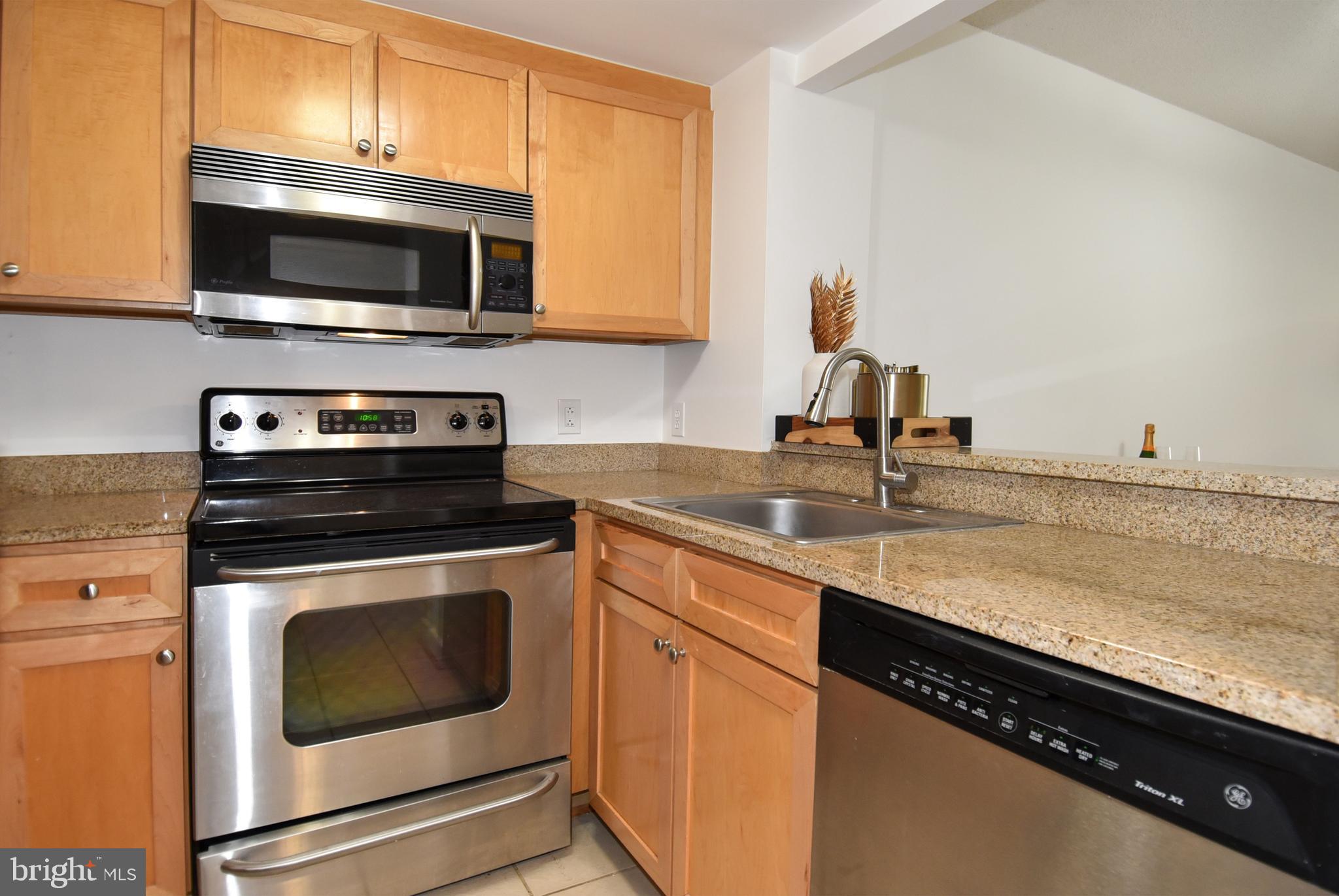 1150 K Street Northwest, Unit 408 Washington, DC 20005 - Photo 15 of 32 a kitchen with granite countertop a sink and a stove top oven