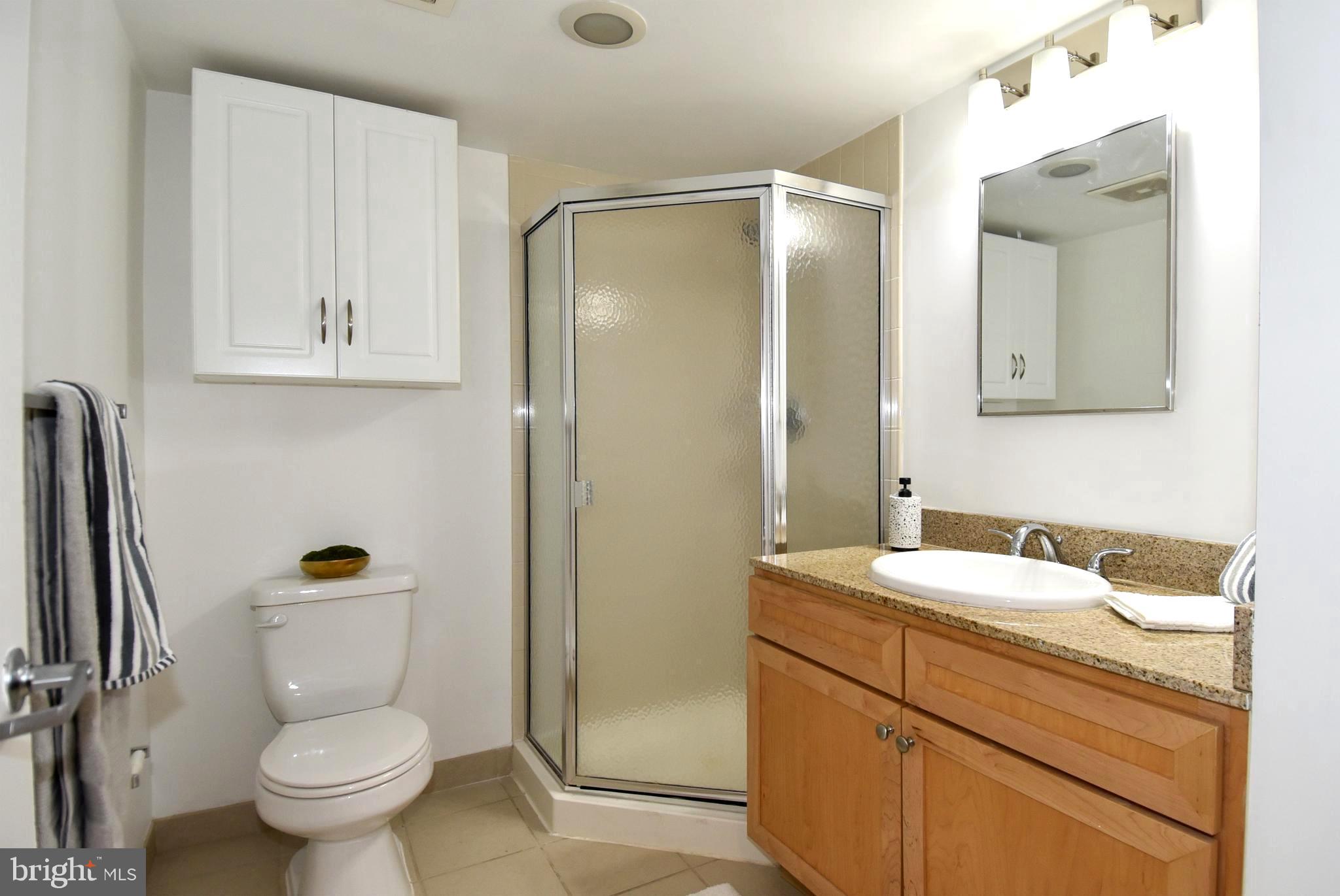 1150 K Street Northwest, Unit 408 Washington, DC 20005 - Photo 22 of 32 a bathroom with a granite countertop sink toilet and shower