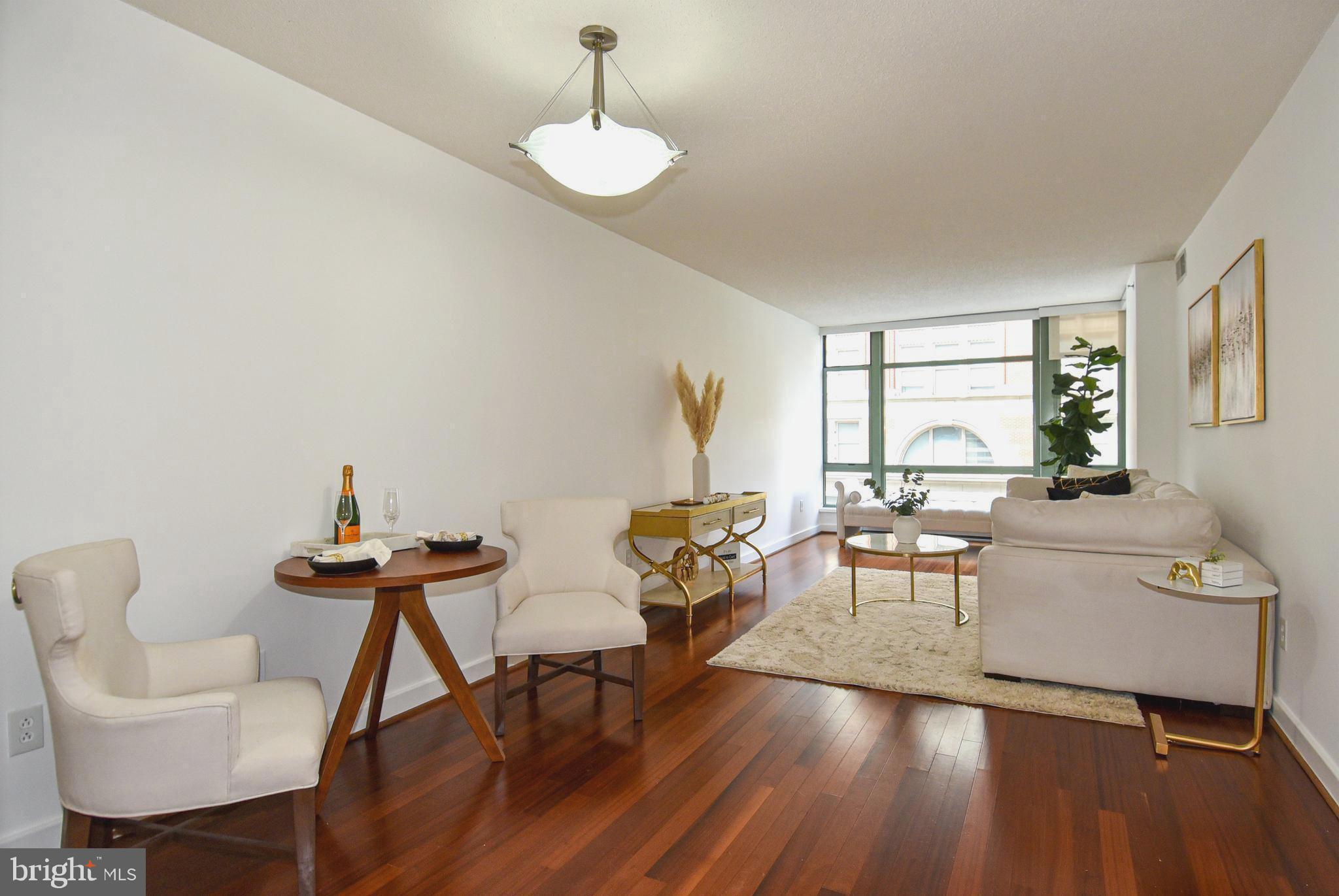 1150 K Street Northwest, Unit 408 Washington, DC 20005 - Photo 31 of 32 a living room with furniture and a wooden floor