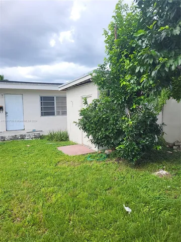 a view of a house with a backyard and a garden