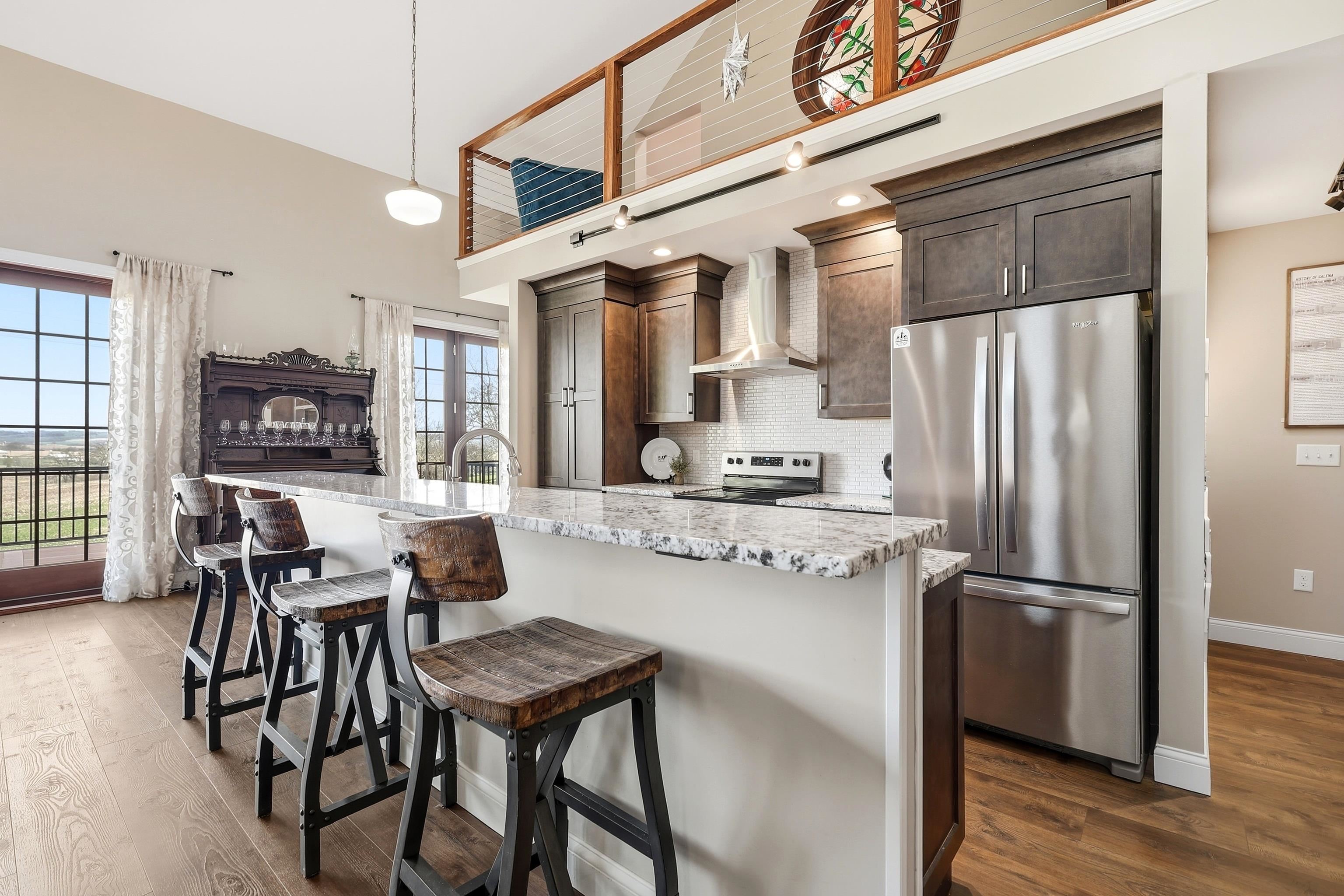 6603 West Council Hill Road Scales Mound, IL 61075 - Photo 14 of 49 a kitchen with stainless steel appliances granite countertop a stove a refrigerator a table and chairs with wooden floor