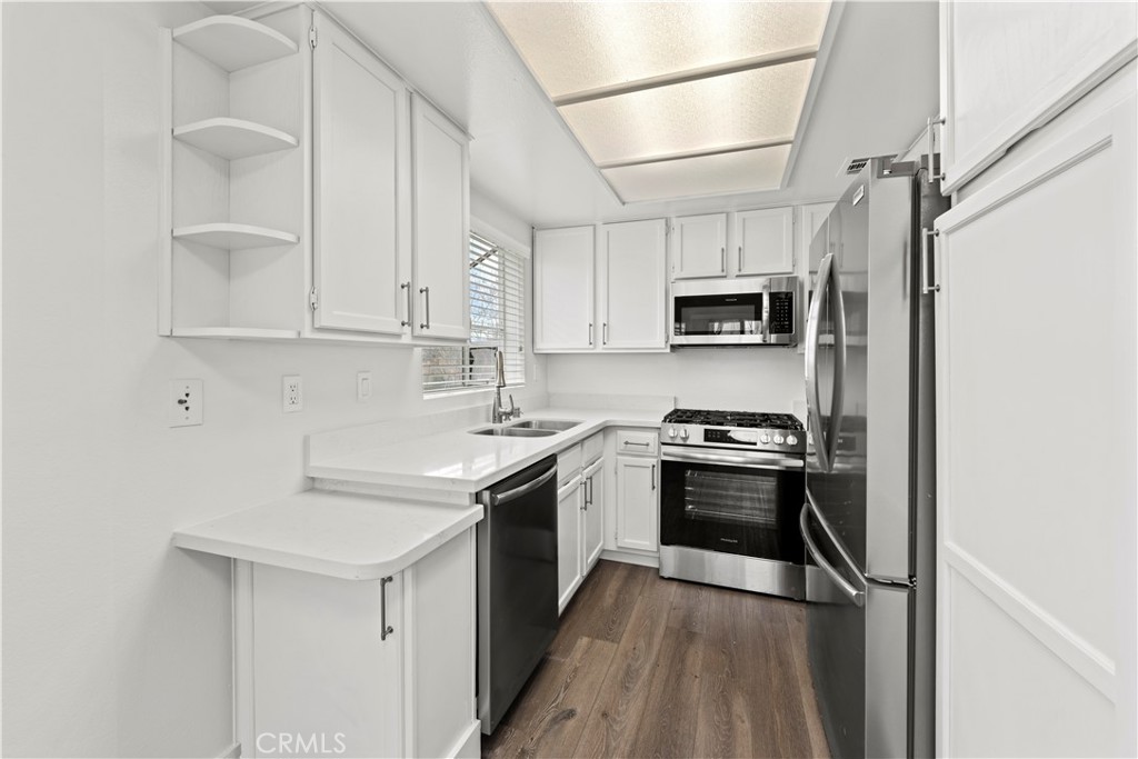 19847 Sandpiper Place, Unit 139 Newhall, CA 91321 - Photo 21 of 50 a kitchen with stainless steel appliances granite countertop a sink stove microwave and refrigerator