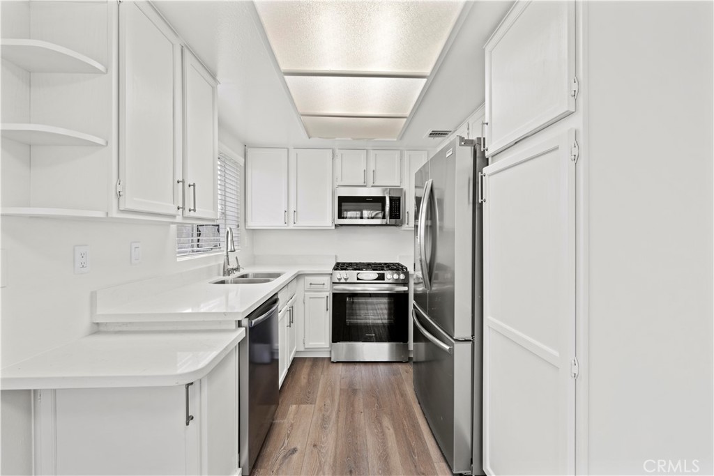 19847 Sandpiper Place, Unit 139 Newhall, CA 91321 - Photo 23 of 50 a kitchen with stainless steel appliances granite countertop a sink stove and refrigerator