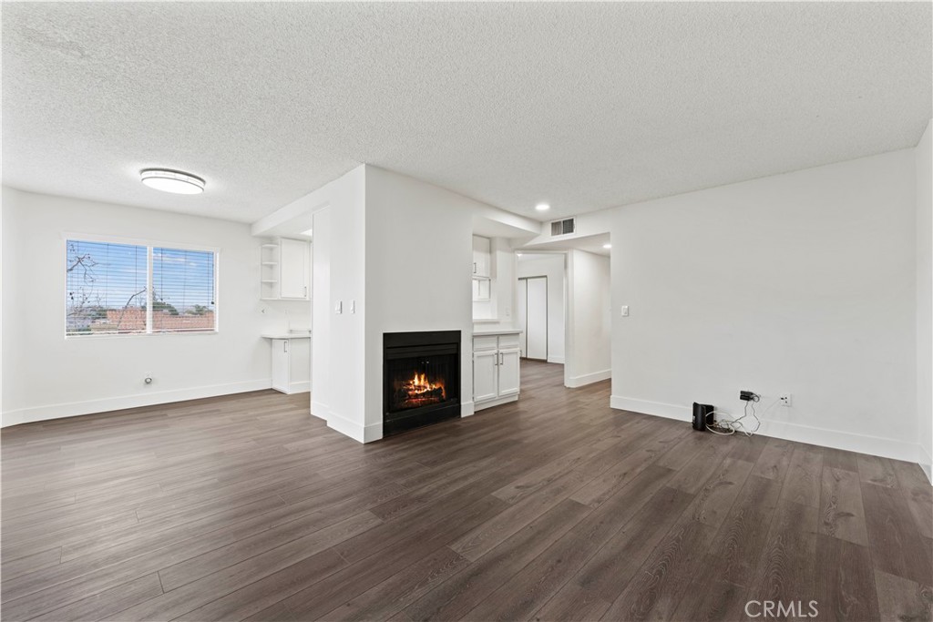 19847 Sandpiper Place, Unit 139 Newhall, CA 91321 - Photo 30 of 50 a view of empty room with wooden floor and fireplace