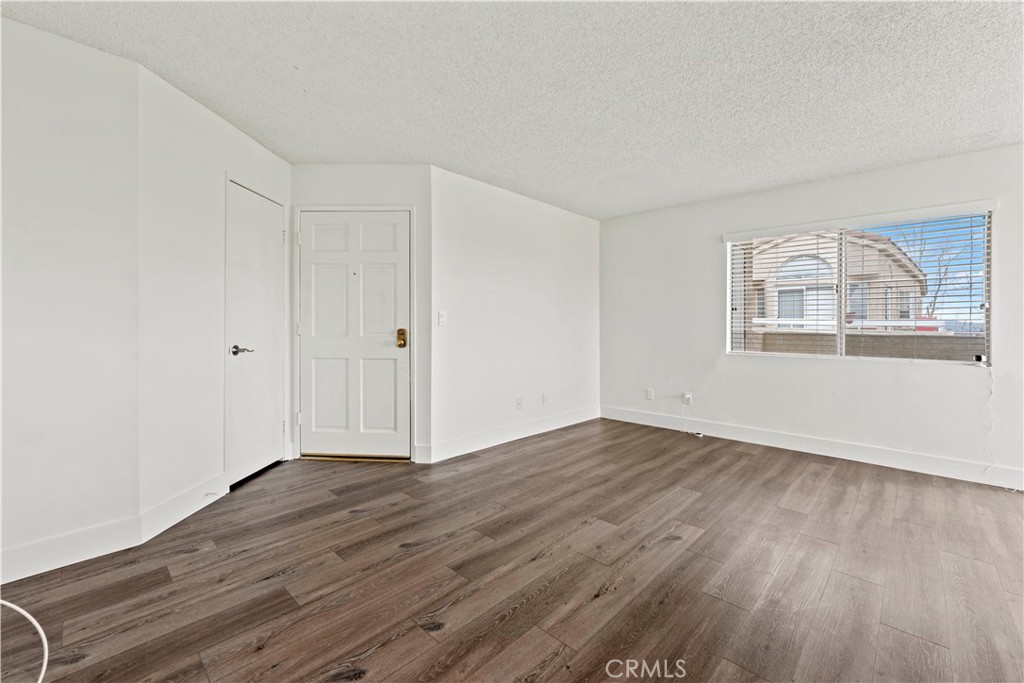 19847 Sandpiper Place, Unit 139 Newhall, CA 91321 - Photo 32 of 50 a view of an empty room with wooden floor and a window