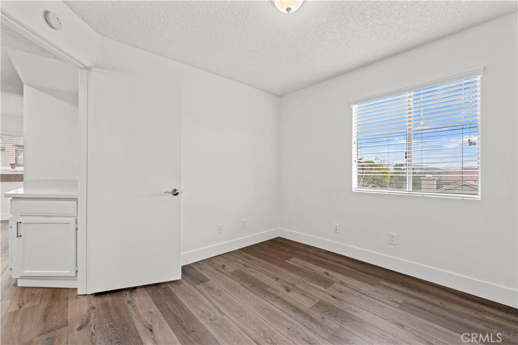 19847 Sandpiper Place, Unit 139 Newhall, CA 91321 - Photo 33 of 50 a view of a room that has wooden floor and white walls