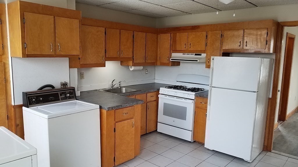 38-40 Pleasant Street Reading, MA 01867 - Photo 11 of 25 a kitchen with a stove sink and refrigerator