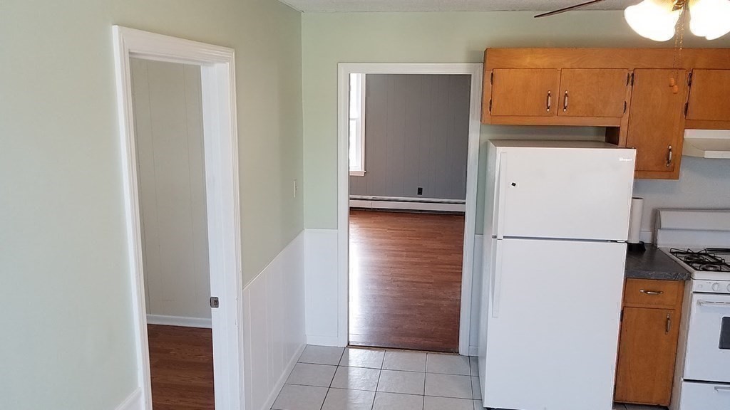 38-40 Pleasant Street Reading, MA 01867 - Photo 12 of 25 a view of a kitchen with a refrigerator