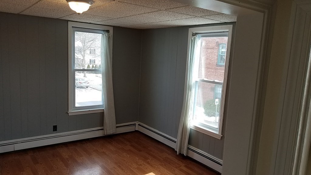 38-40 Pleasant Street Reading, MA 01867 - Photo 15 of 25 a view of an empty room with wooden floor and a window
