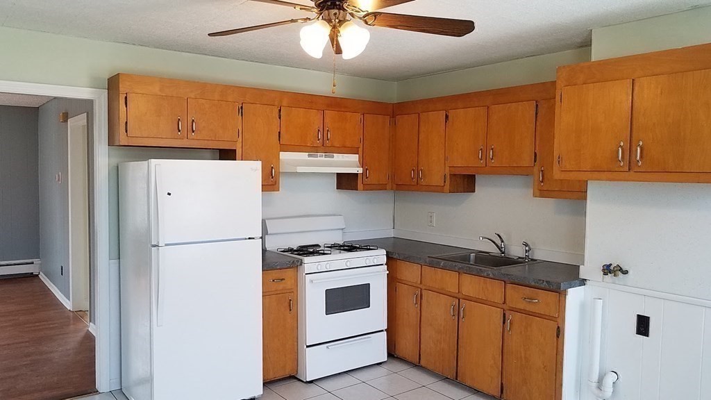 38-40 Pleasant Street Reading, MA 01867 - Photo 8 of 25 a kitchen with a white cabinets and white appliances