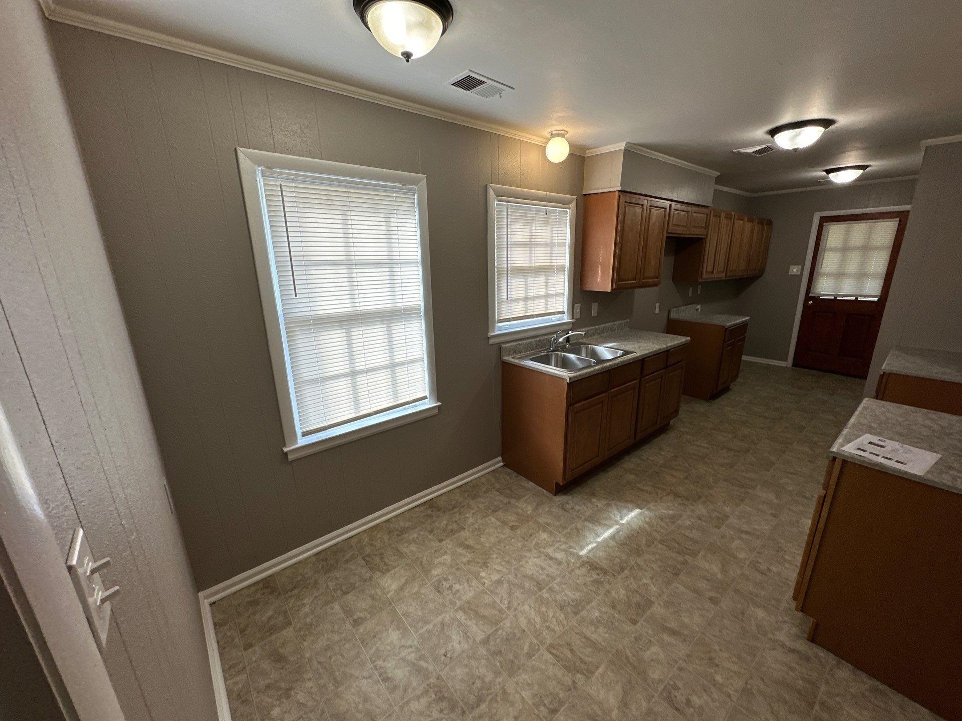 10 West Mitchell Road Memphis, TN 38109 - Photo 10 of 11 Kitchen with light floors, ornamental molding, visible vents, a sink, and brown cabinets