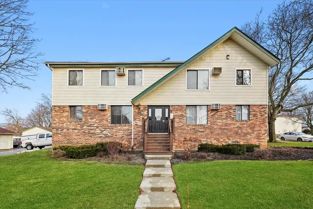 a front view of a house with a garden and yard
