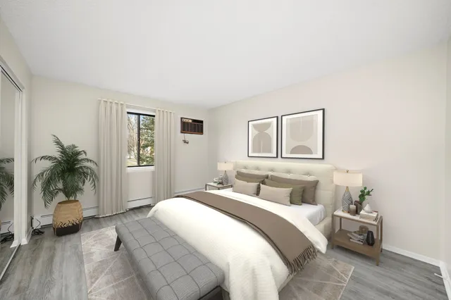 a bedroom with a large bed and a potted plant