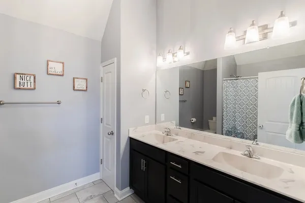 a bathroom with a double vanity sink a mirror and shower
