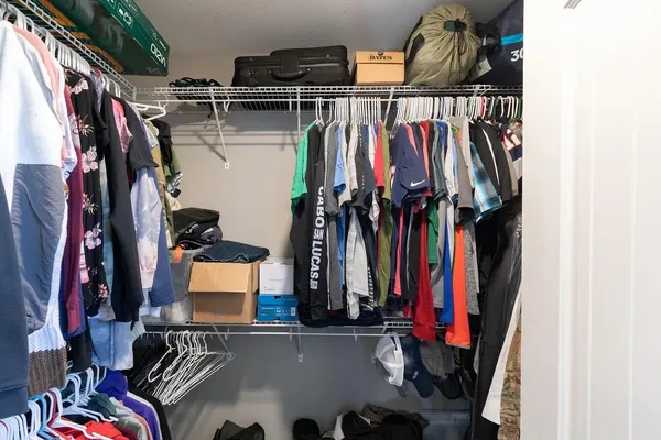 a view of walk in closet with clothes and shoes