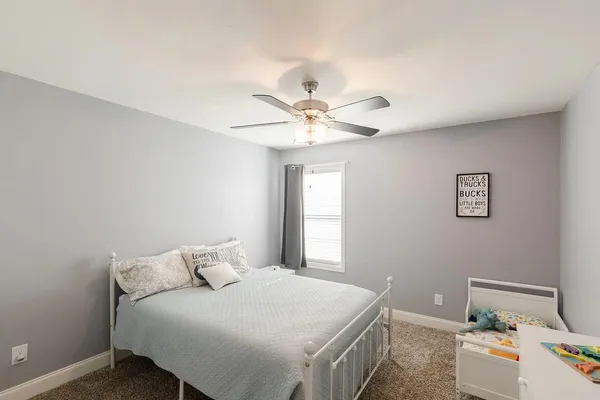 a bedroom with a bed and a ceiling fan