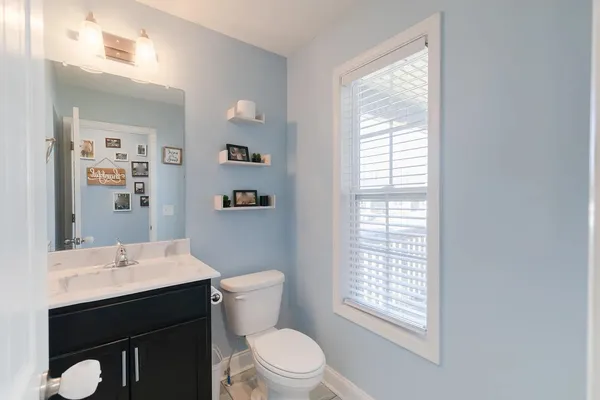 a bathroom with a sink a toilet and window