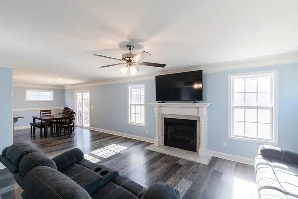 a living room with furniture a fireplace and a flat screen tv