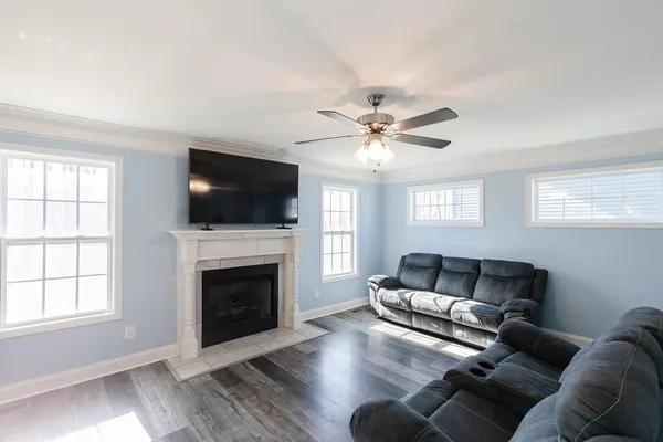 a living room with furniture a flat screen tv and a fireplace