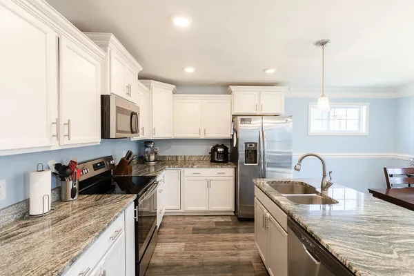 a kitchen with a sink stove top oven and refrigerator
